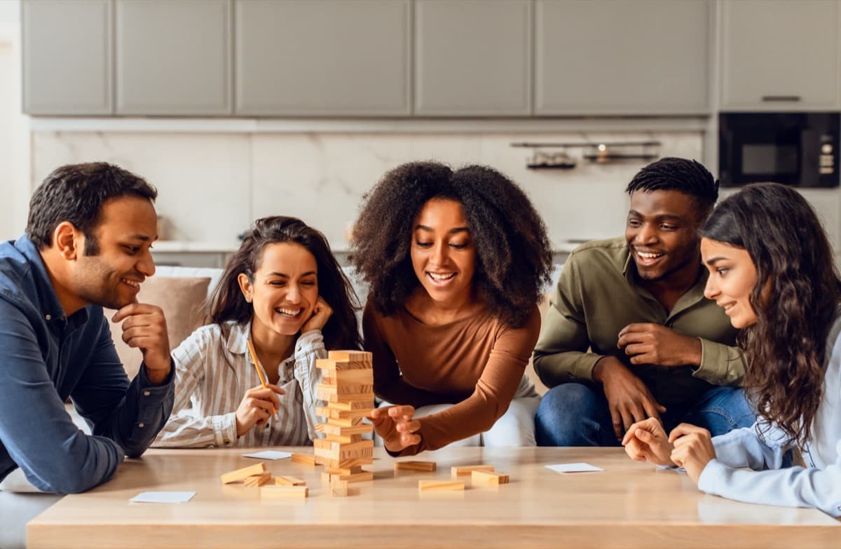 Friends laughing around a game of Jenga